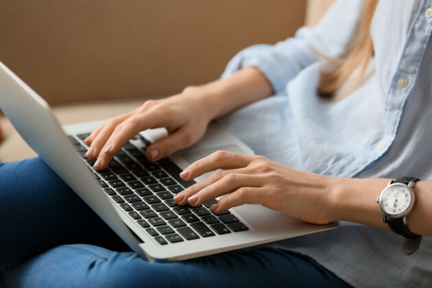 电脑美女在家里用笔记本电脑 特写沙发设备网站