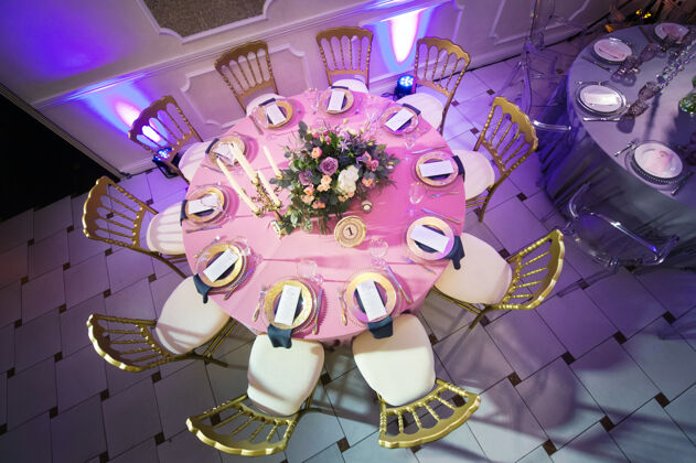 玻璃用百合花和郁金香装饰餐厅内部婚礼桌上的节日晚餐为庆祝而装饰的桌子宴会郁金香长