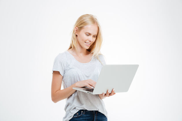 微笑一个快乐的女人用笔记本电脑在白色背景上隔离的肖像人便携式休闲