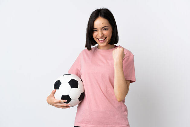 训练年轻的白种人女子与足球庆祝胜利孤立的白色背景墙女孩足球
