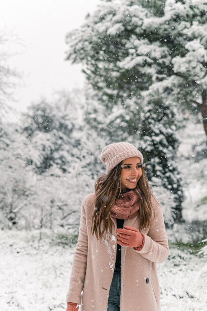 内容穿着暖和衣服的快乐女人站在雪林里 一边看一边享受冬日的周末公园外套欢呼