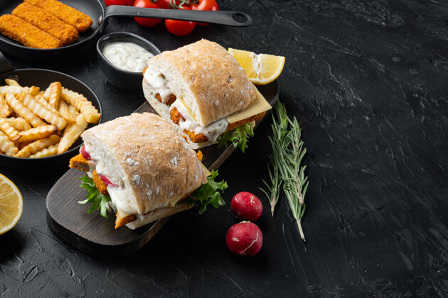 薯条汉堡包配鱼指 新鲜生菜 西红柿和鞑靼酱 放在木片上面包复印空间奶酪