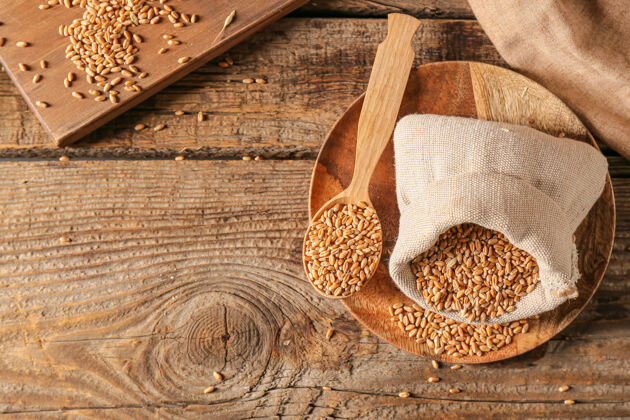 面筋木质背景上放着麦粒的袋子和勺子扁豆谷物小麦