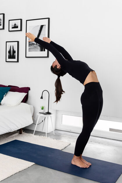 健身年轻苗条的女人在家里的现代简约卧室练习瑜伽健康美丽有氧爱好