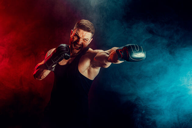 模特留着胡须 纹身的泰拳运动员 身穿黑色汗衫 戴着拳击手套 在黑暗的墙上与烟雾搏斗运动概念男性比赛运动员