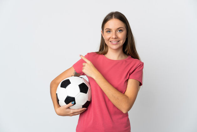 足球立陶宛一名年轻女子被隔离在白色背景下 手里拿着足球 指着侧面成年人女人稍后