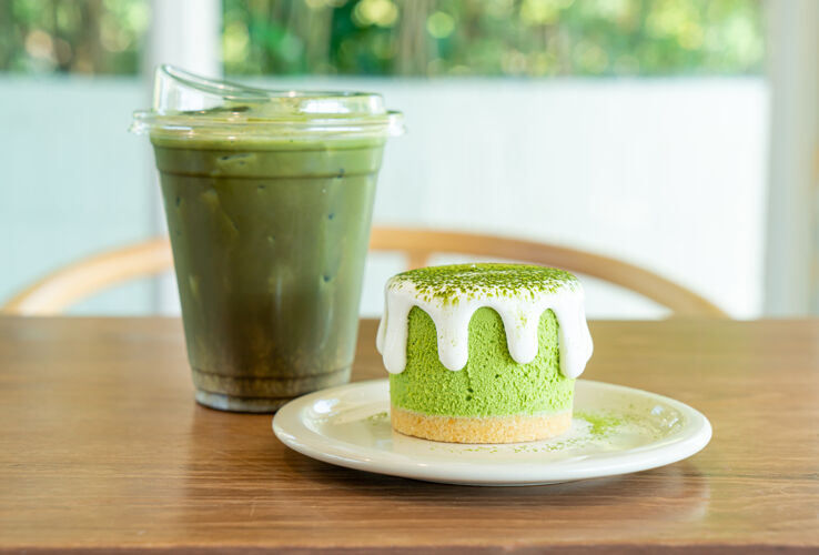 日本在咖啡馆的桌子上放着一个绿茶芝士蛋糕和一个绿茶杯配料茶餐