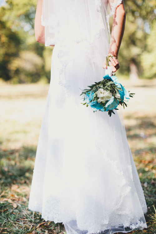 玫瑰身穿白色礼服的新娘手持婚礼花束牡丹女性花束