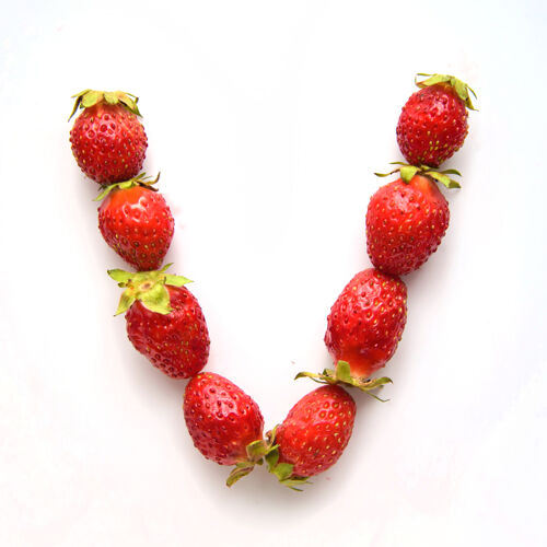叶子白色背景上红色新鲜草莓的英文字母表的字母v健康健康饮食