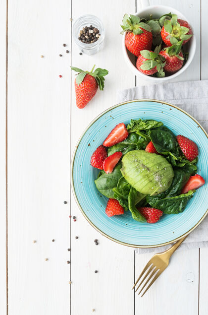 菠菜健康饮食草莓沙拉 鳄梨 菠菜在白色木制背景上俯视平面食物开胃菜鳄梨
