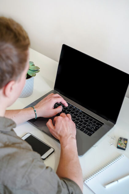 男人一个男性程序员在明亮的办公室或远离家的笔记本电脑屏幕前工作信息无线职业