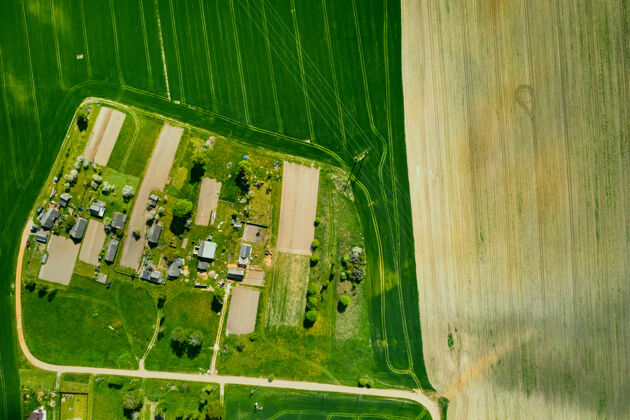道路白俄罗斯一片播种的绿地和一个小村庄的俯视图西部的农田村庄.春天在一个小村庄播种雄蜂景观农作物