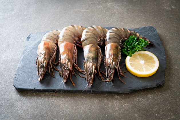 国王新鲜虎虾或虾在黑板上木材贝类餐