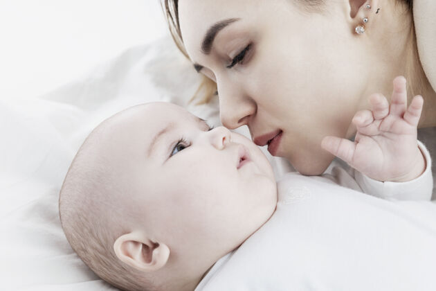护理一个年轻的妈妈亲吻一个新生的婴儿爱和温柔特写镜头家庭人类感情