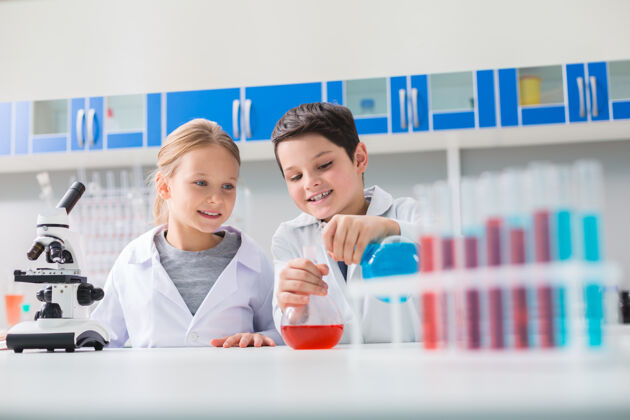 学生年轻的化学家快乐积极的聪明孩子们在学习化学的同时站在一起做实验发现样品智能