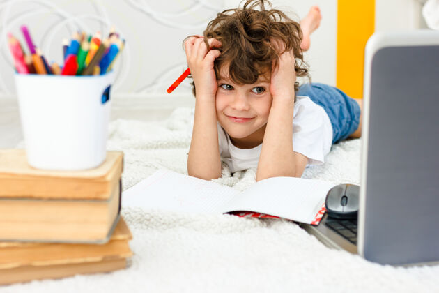 孩子卷发男孩正忙于电脑那个男生抓着头看着班长家庭教育 远程教育的困难概念看考试头