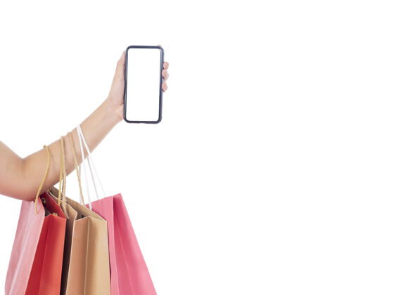 买家拿着白屏智能手机和白墙上购物袋的女人们女人商业支付