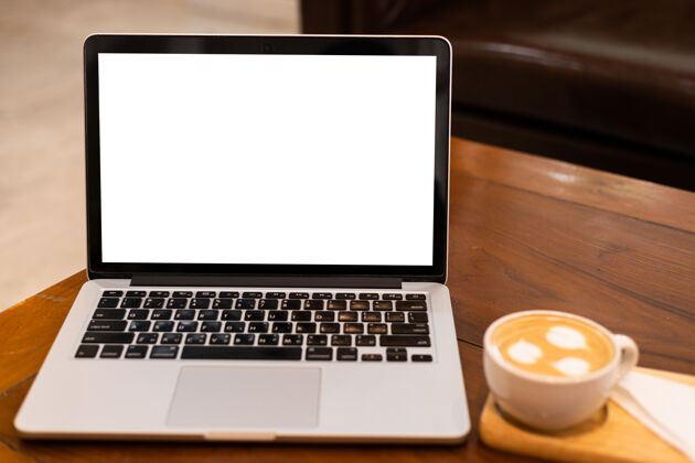 笔记本电脑模拟笔记本电脑与空屏幕上的咖啡杯咖啡店的背景 白色屏幕的桌子互联网工作键盘