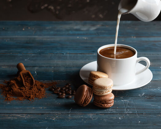 食物牛奶放在咖啡杯上 咖啡豆 磨碎的咖啡和木制背景上的杏仁饼杏仁饼杯子浓缩咖啡