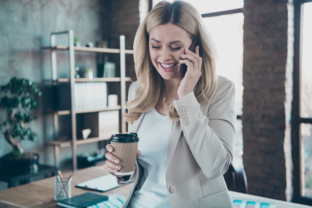 企业家商务女士手持电话杯交谈的照片成熟手机电话