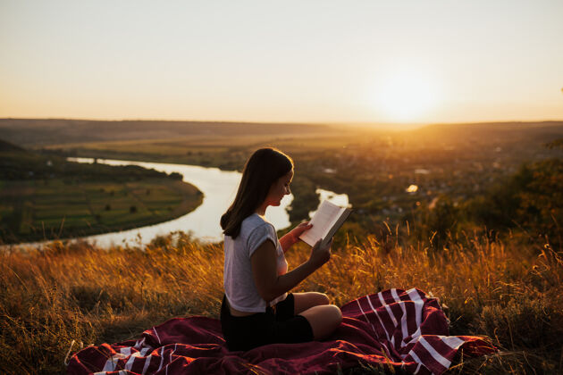 夜晚女孩在风景优美的山上看书 享受假期的时光阳光美丽页面