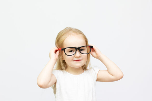 表情金发时尚的小女孩 戴着红黑相间的眼镜 白色的肖像画小聪明孩子