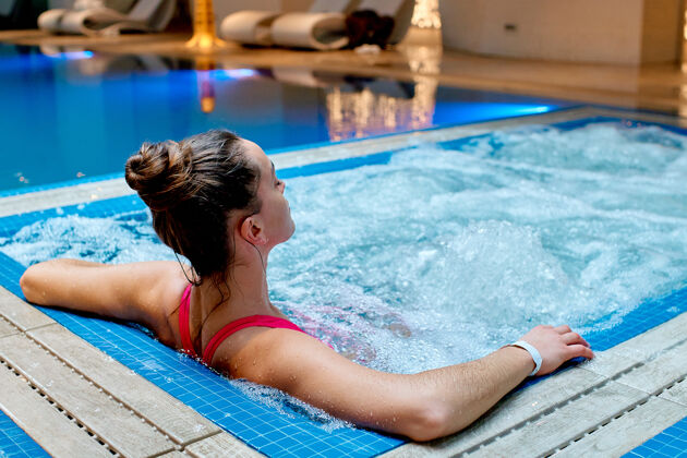 浴缸年轻健康的一位女士独自在健康温泉度假村的浴缸里放松泡泡放松游泳