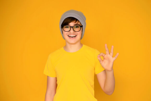 运动黄色背景上一个12-13岁的英俊少年的画像休闲头发时尚