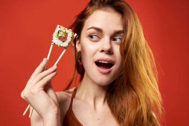年轻人快乐红发女人寿司卷减肥趣味特写嘴持有美丽的