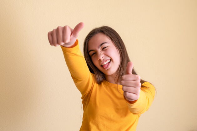 青少年竖起大拇指的年轻女人积极水平竖起大拇指
