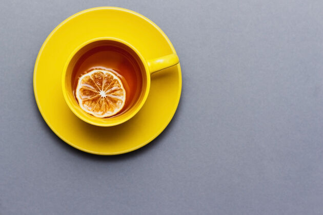 颜色趋势热红茶配柠檬片灰色顶视图表.黄色杯子打开灰色颜色2021年饮料颜色双重