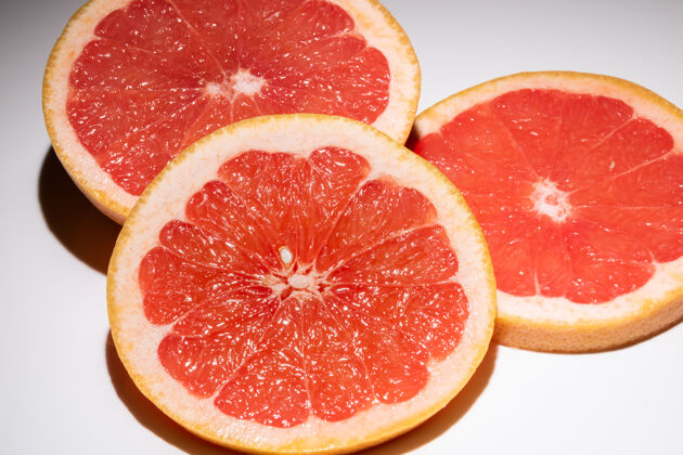 切割在白色表面上分离出的三片葡萄柚新鲜水果圆片叶隔离水果葡萄柚水果隔离