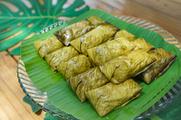 自然卡通玛（Khaotommad）或糯米蒸绿豆是当地的传统泰国菜甜点它它被香蕉叶包裹着健康米饭汤姆