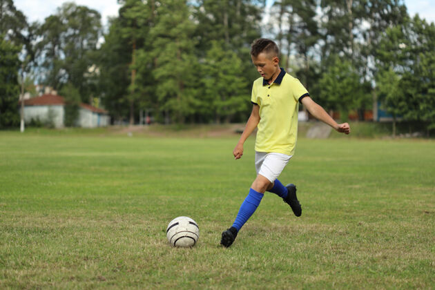 球员穿着黄色t恤的男孩足球运动员在足球场上拿着球欧洲男性竞争