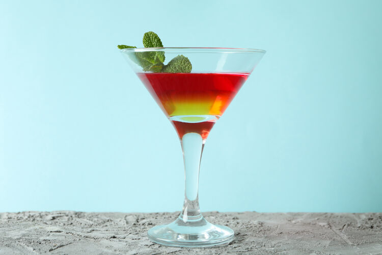 美食鸡尾酒杯 蓝色背景上有草莓和橙色果冻鸡尾酒饮料马提尼酒
