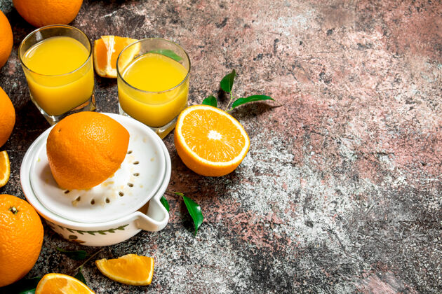 挤压一杯橙汁和一台榨汁机甜食多汁早餐
