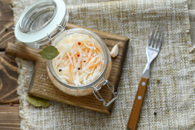 卷心菜酸的 腌制的泡菜 胡萝卜和月桂叶放在玻璃罐里营养素食新鲜