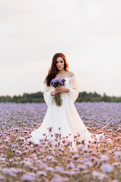 女性在普罗旺斯一片盛开的田野里 一位身着白色连衣裙的美丽女孩手拿花束 在浪漫的气氛中翩翩起舞女士美丽自然