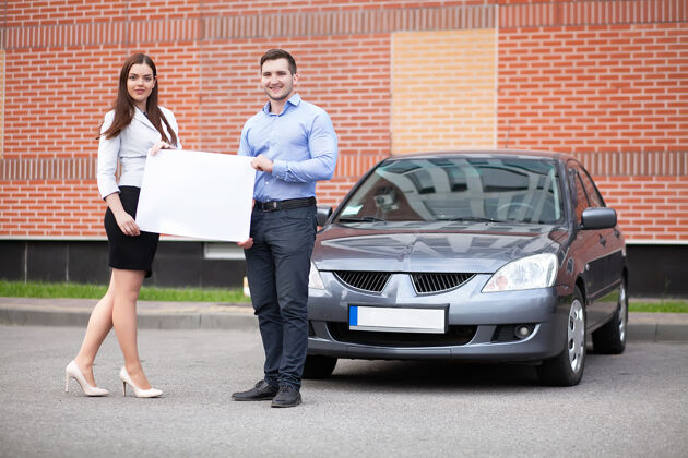 租赁一对年轻夫妇拿着一张白纸放在汽车表面快乐工业车辆