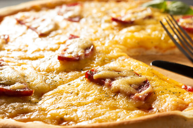 木头木桌上的意大利香肠披萨铺设奶酪西红柿