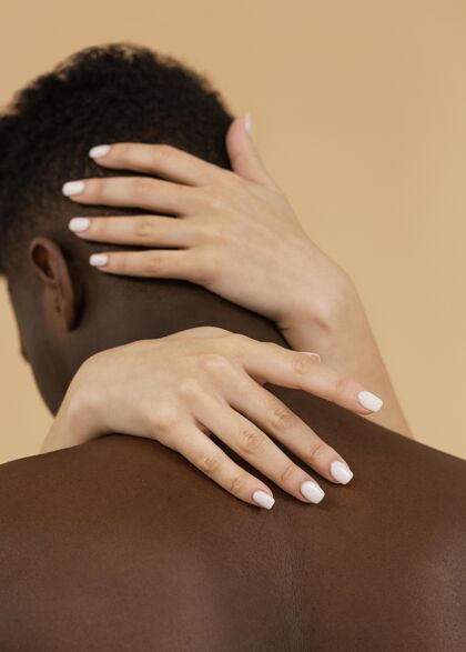 黑人男子近距离的手拉着男人的背影特写黑人橙色背景