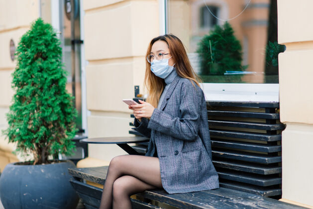 保护带着口罩的亚洲女人 城市里的护面 咖啡馆病毒爆发避免女性