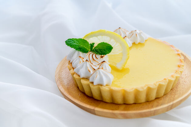 糕点柠檬酸柑橘蛋糕在木盘和白布背景 蛋糕和面包店的概念凝乳水果派
