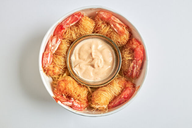 薯条鸟瞰一个立方体的炸虾包在kataifi意大利面和龙汁服务鱼餐桌口味