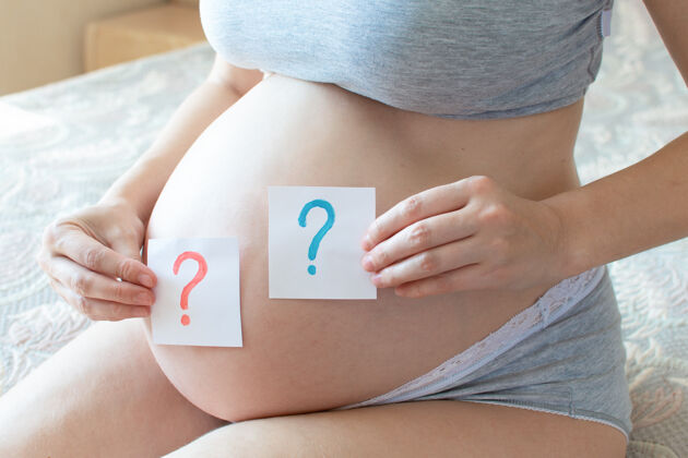 马克性别派对怀孕了肚子里有一个问号男孩和女孩在手怀孕婴儿等待