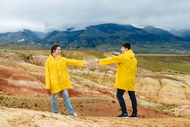 风景两个年轻的游客在彩山上握手自然山女人