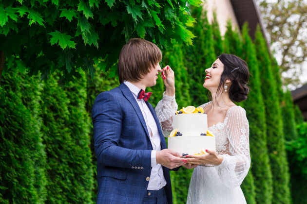 活动新婚夫妇和伴娘们在婚宴上尽情享受 在新鲜空气中一起吃结婚蛋糕浪漫娱乐一起