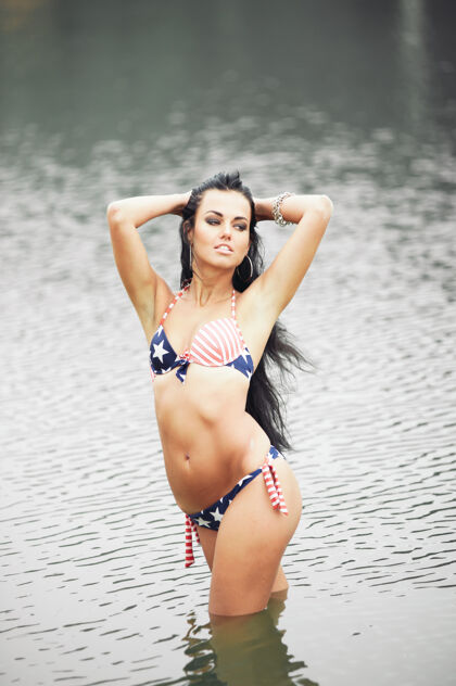 女士海滩上穿着泳装 挂着美国国旗的美丽健美的年轻女子女性窒息景点