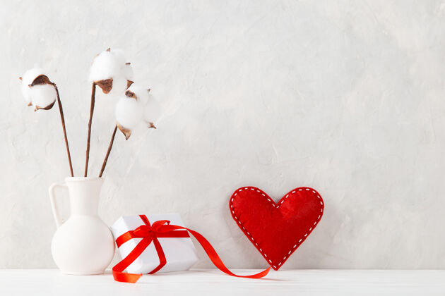 关怀一个用棉花做的花瓶 一个红色的心形的花瓶 一个靠在墙上的礼物 一个概念 一张情人节的明信片庆典花朵情人节