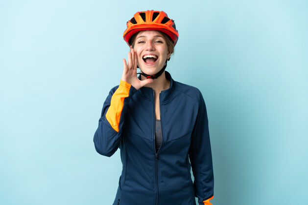信息一个年轻的骑自行车的女人被隔离在蓝色的背景下 张大嘴巴大喊大叫情绪成人前面